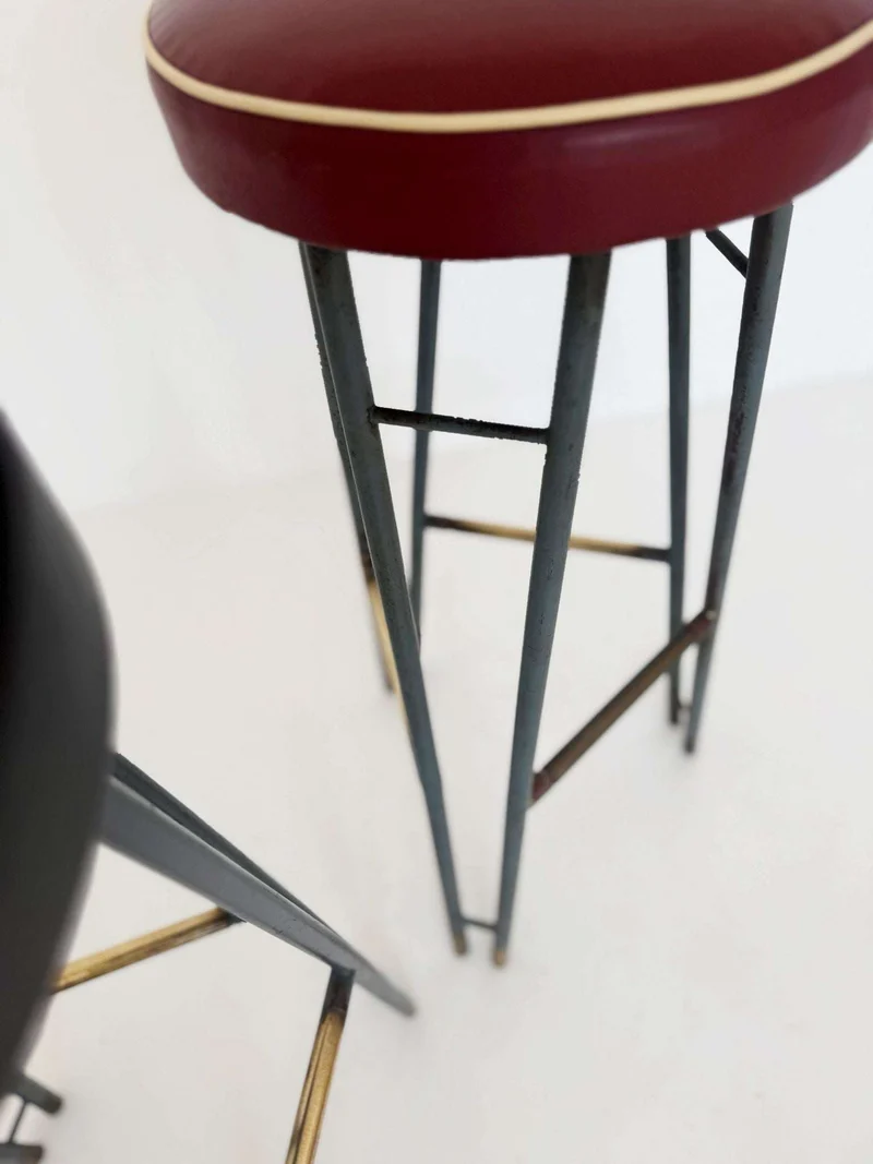 Una coppia di sgabelli alti con struttura in metallo verniciato, caratterizzati da un design elegante