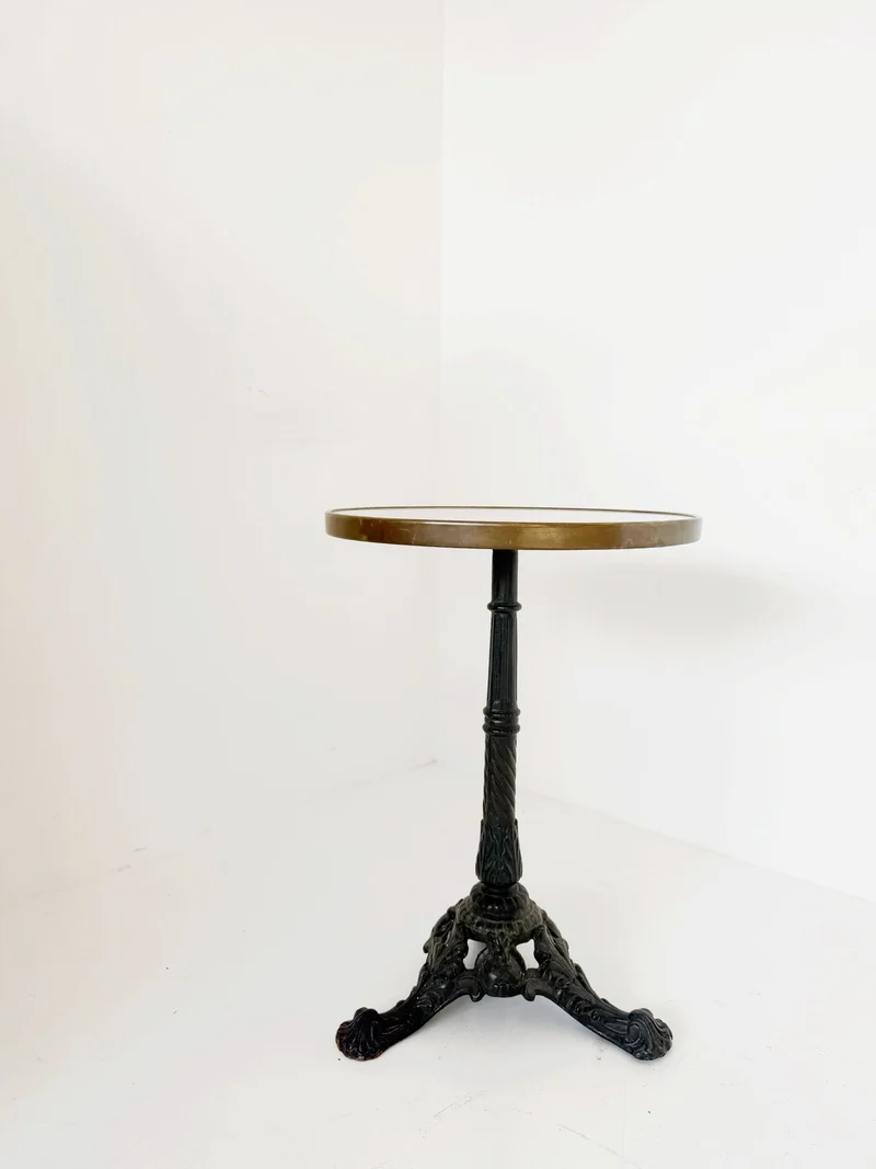 Tavolino da bistrot con piano tondo in marmo bianco di Carrara e bordo in ottone brunito.