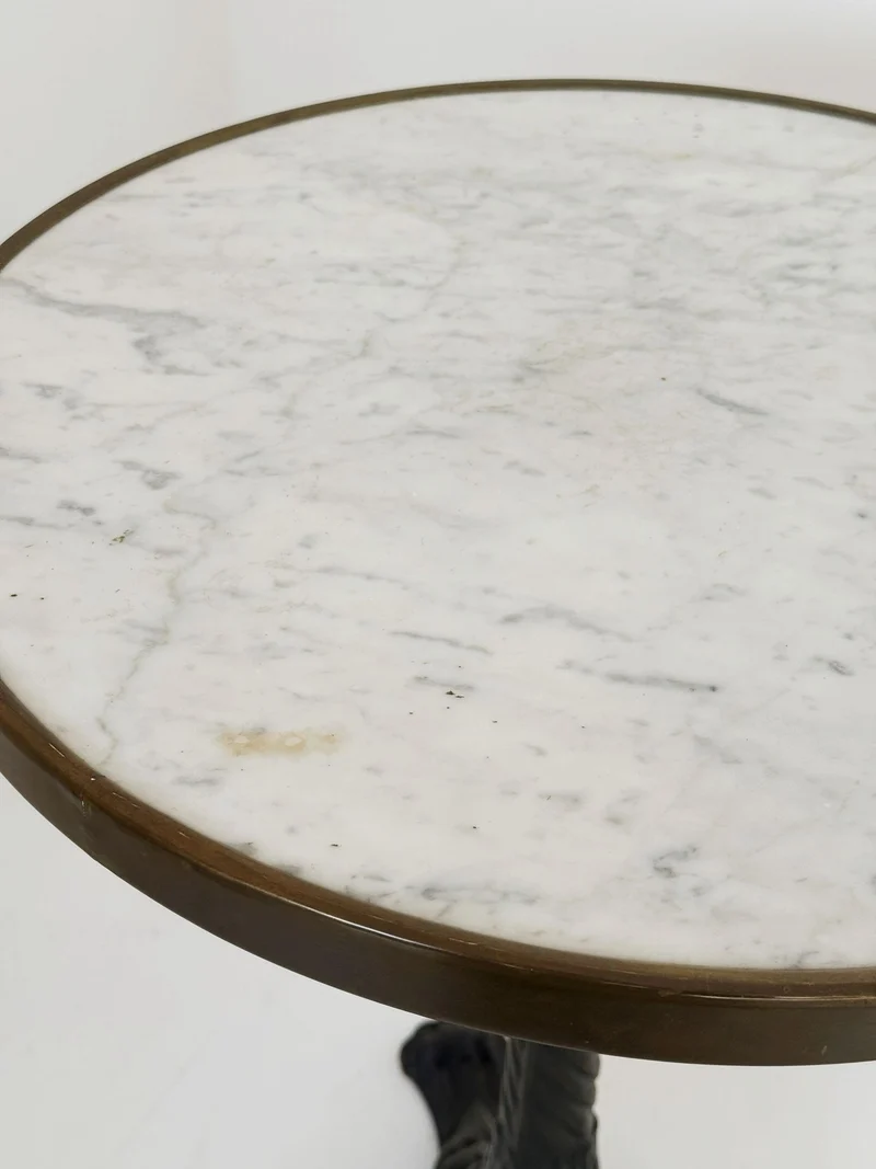 Tavolino da bistrot con piano tondo in marmo bianco di Carrara e bordo in ottone brunito.
